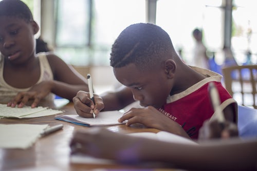 boy in a classroom writing his homework